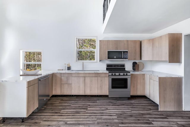 kitchen featuring gas range, a sink, dishwasher, light brown cabinets, and black microwave