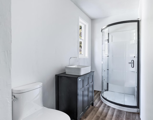full bath with a shower stall, toilet, and wood finished floors