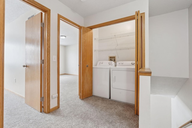 clothes washing area with washing machine and clothes dryer, laundry area, and carpet