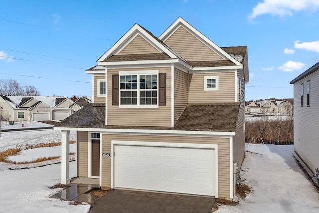 view of front of property with an attached garage, driveway, and roof with shingles