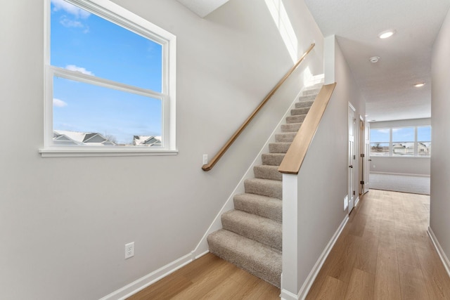 stairs featuring recessed lighting, wood finished floors, and baseboards