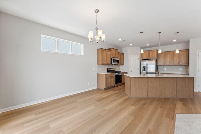 kitchen featuring brown cabinetry, stainless steel appliances, light countertops, and a sink