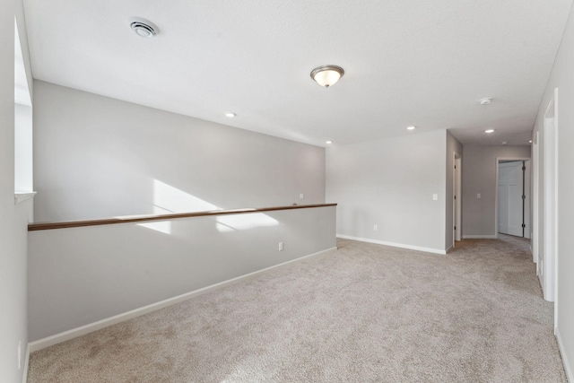 unfurnished room featuring visible vents, recessed lighting, baseboards, and carpet