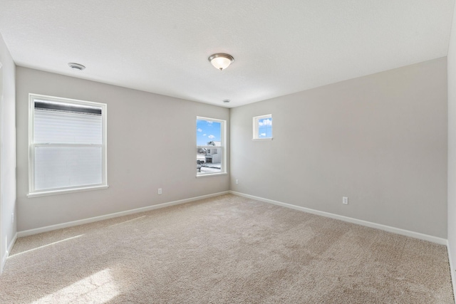 spare room featuring carpet flooring and baseboards