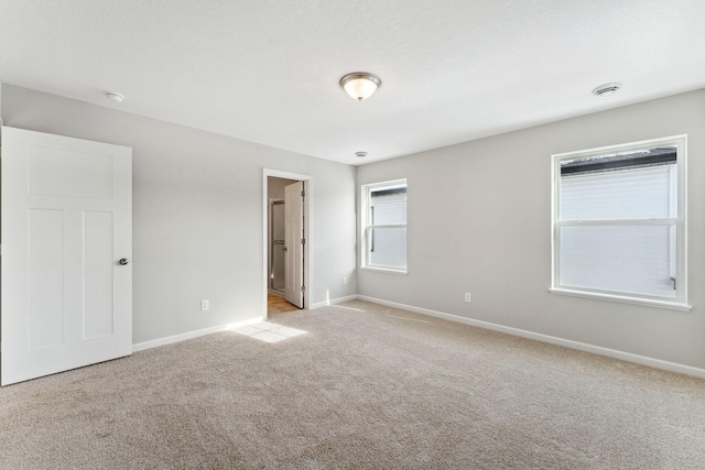 empty room featuring baseboards and carpet flooring