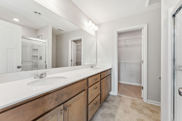 full bath with a sink, visible vents, a stall shower, and a spacious closet