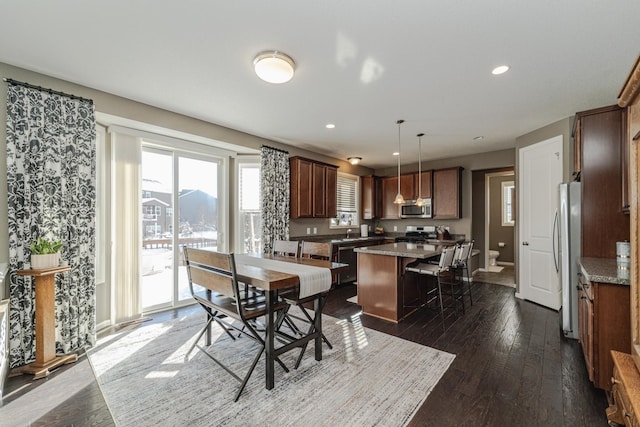 dining space with dark wood finished floors, recessed lighting, and baseboards