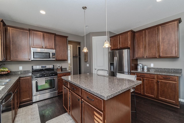 kitchen featuring a center island, dark wood-type flooring, recessed lighting, appliances with stainless steel finishes, and hanging light fixtures