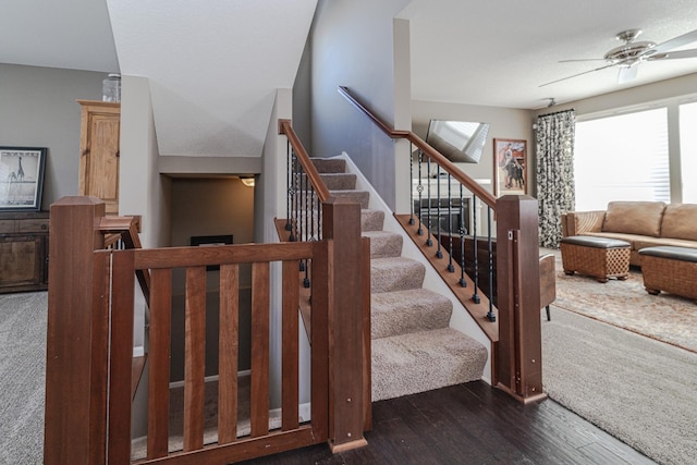 stairway with ceiling fan and wood finished floors