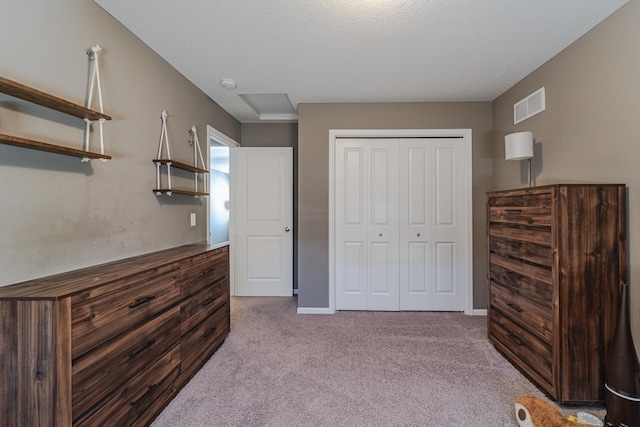 carpeted bedroom featuring baseboards, visible vents, and a closet