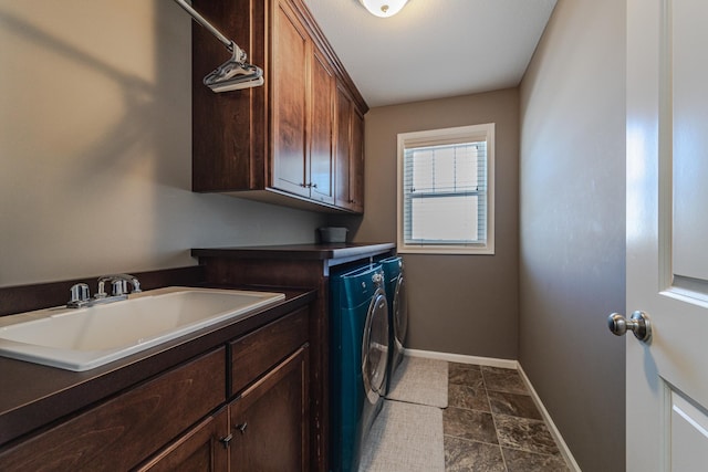 laundry room featuring cabinet space, independent washer and dryer, baseboards, and a sink