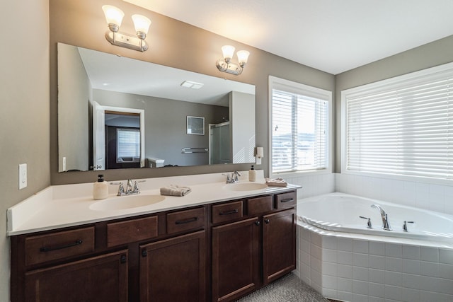 full bathroom featuring double vanity, a shower stall, a garden tub, and a sink