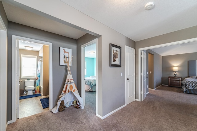 corridor featuring baseboards and carpet floors