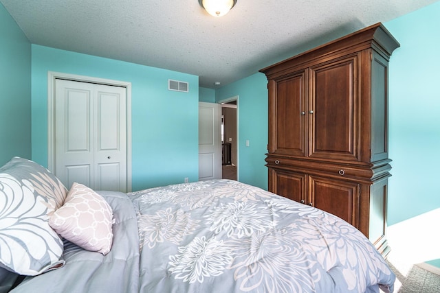 bedroom with visible vents, a closet, and a textured ceiling