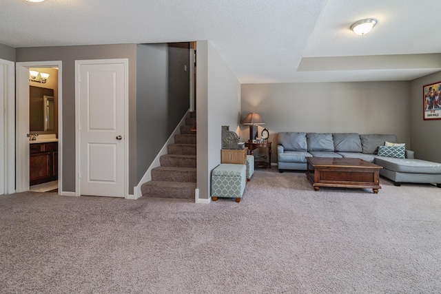 living area featuring baseboards, carpet floors, a textured ceiling, and stairs