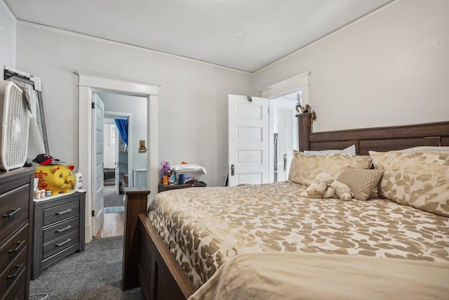 bedroom with crown molding and dark colored carpet