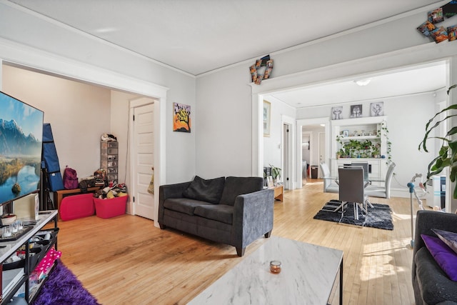 living area with crown molding and hardwood / wood-style flooring