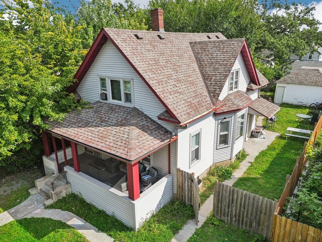 exterior space with fence private yard, a chimney, and roof with shingles