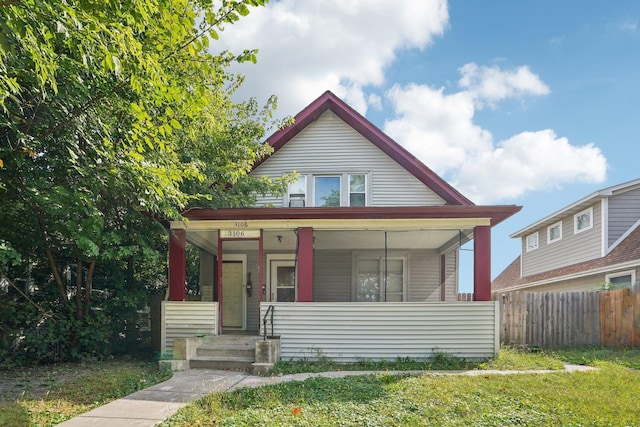 bungalow with a porch and fence