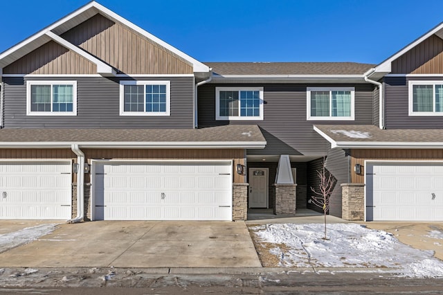 view of front facade featuring an attached garage, driveway, and a shingled roof