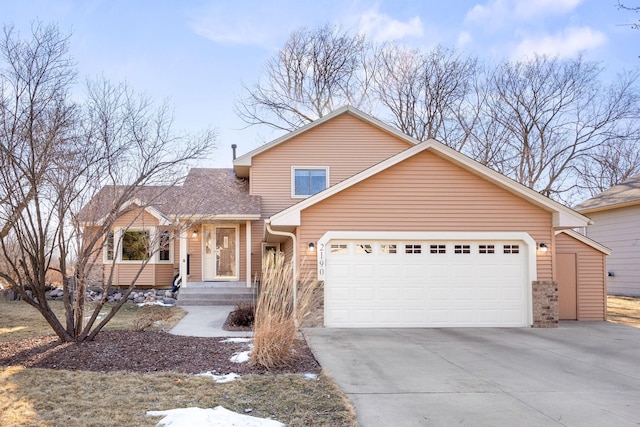 view of front of property featuring driveway, an attached garage, and a shingled roof