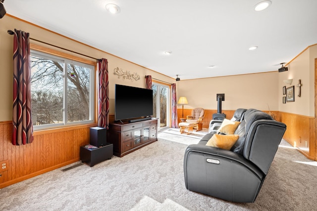 carpeted living room featuring recessed lighting, a healthy amount of sunlight, wood walls, and wainscoting