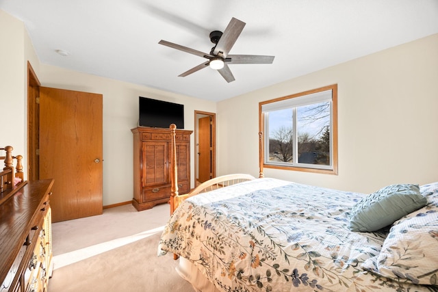 bedroom with light colored carpet, baseboards, and ceiling fan