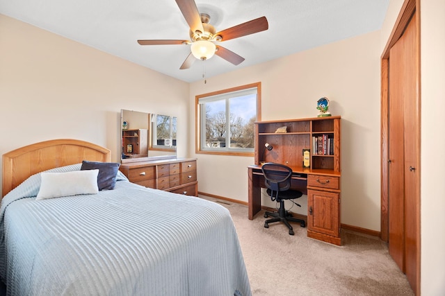 bedroom featuring ceiling fan, baseboards, a closet, and light carpet