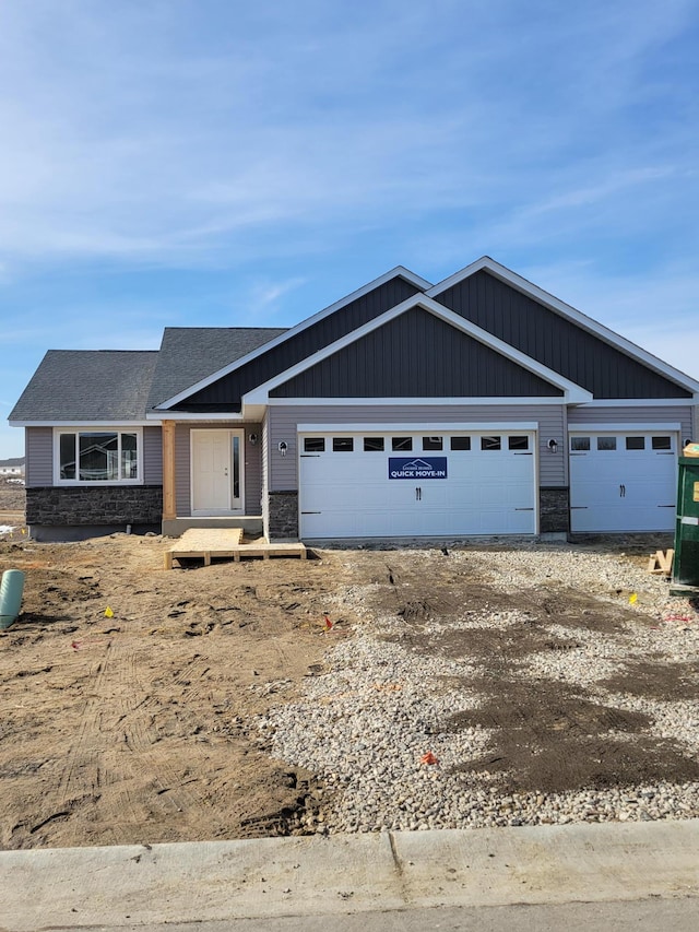 view of front of home featuring stone siding, driveway, and an attached garage