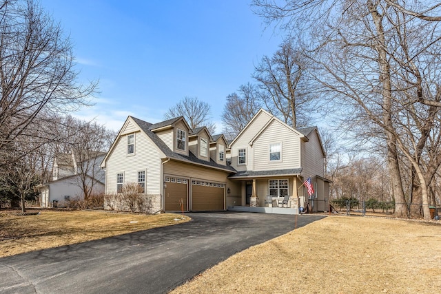 view of front facade featuring a front yard, an attached garage, fence, and driveway