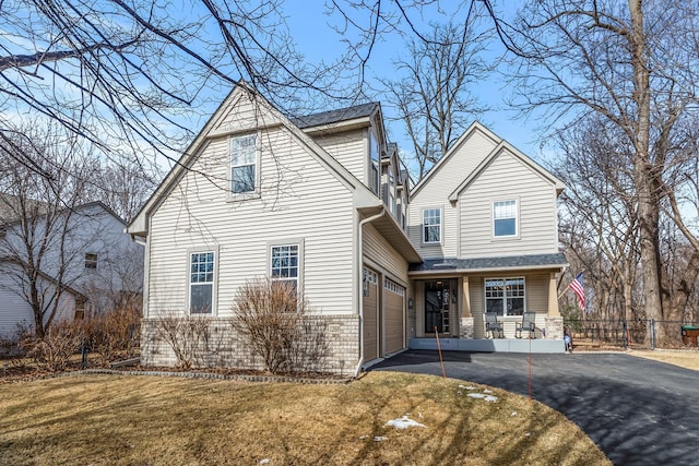 view of front of home with a front yard, fence, a garage, and driveway