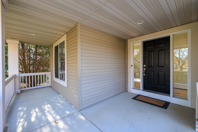 view of exterior entry featuring covered porch