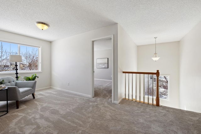 living area featuring baseboards, a textured ceiling, and carpet flooring