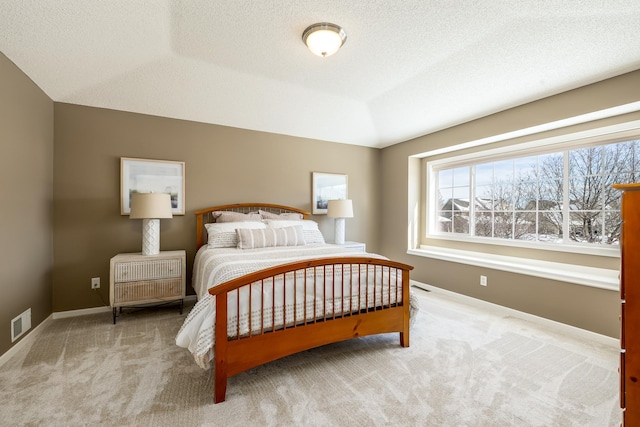 bedroom featuring a textured ceiling, carpet, visible vents, and baseboards