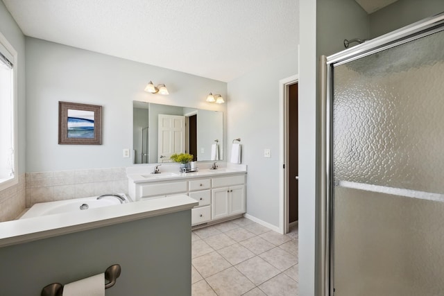 full bath featuring a garden tub, double vanity, a sink, a shower stall, and tile patterned floors