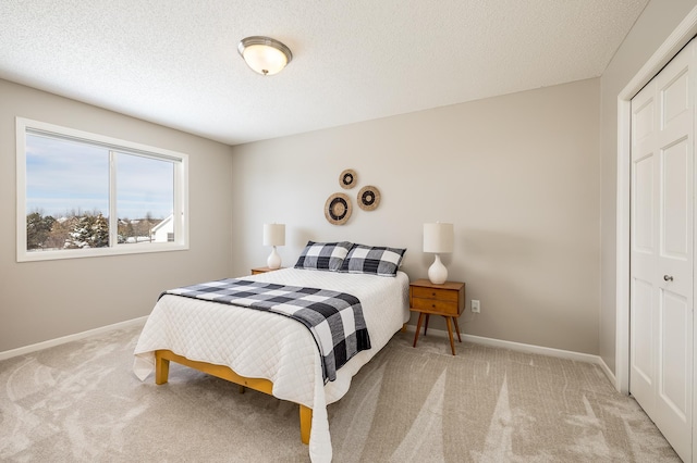 bedroom featuring baseboards, carpet floors, and a textured ceiling