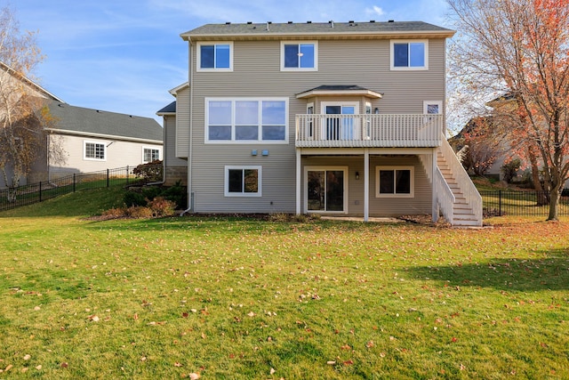 back of property featuring stairway, a fenced backyard, a yard, and a wooden deck