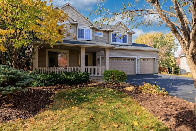 view of front of property with aphalt driveway, a garage, and covered porch