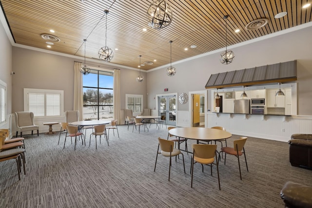 dining area featuring carpet, visible vents, a high ceiling, ornamental molding, and wooden ceiling