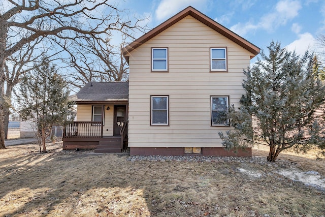 view of front of house featuring roof with shingles and a deck