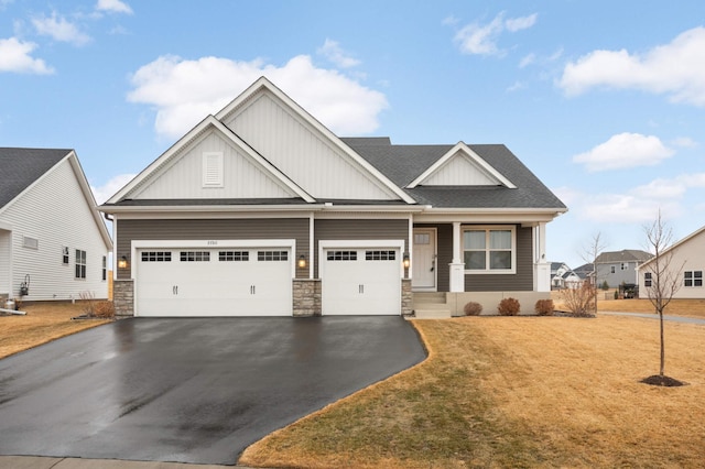 craftsman house featuring driveway, roof with shingles, a front lawn, stone siding, and board and batten siding