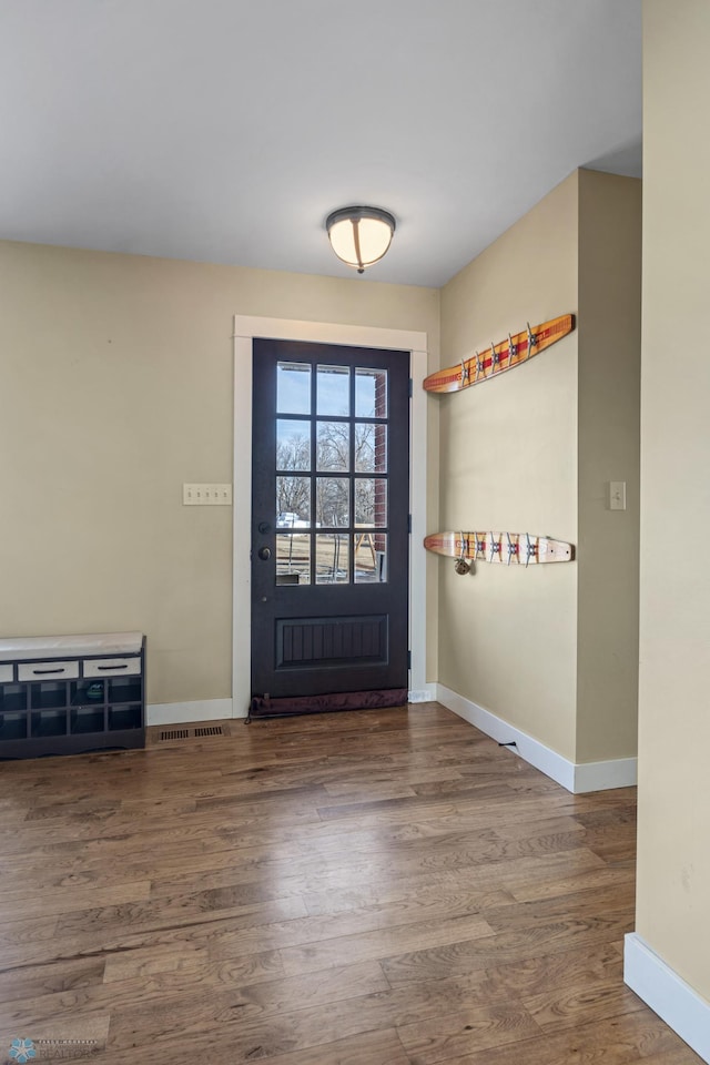 foyer with baseboards and wood finished floors