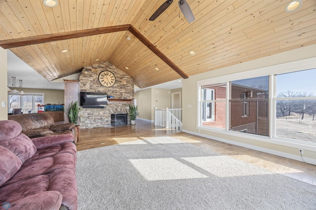 living area featuring a stone fireplace, wooden ceiling, baseboards, and wood finished floors