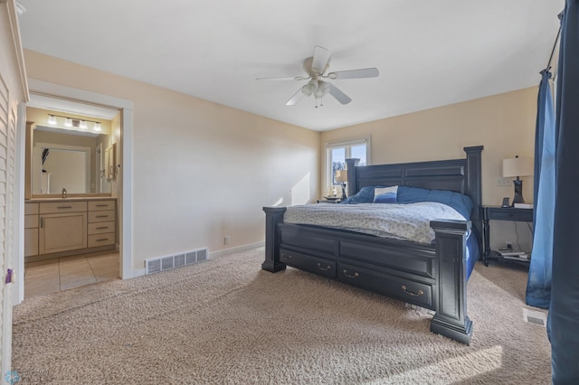 carpeted bedroom featuring visible vents, connected bathroom, baseboards, and ceiling fan