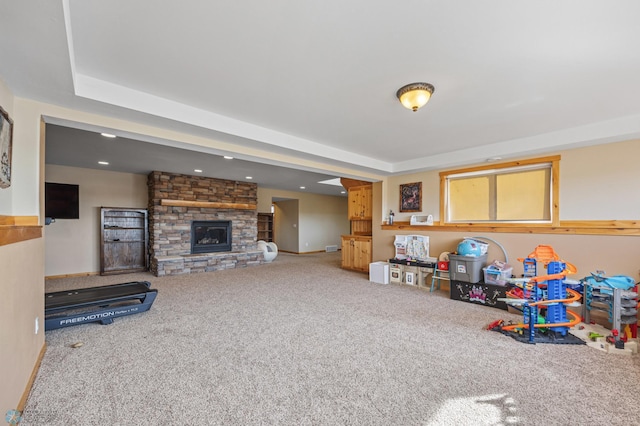 game room featuring carpet and a stone fireplace