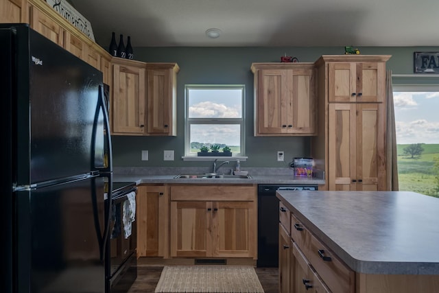 kitchen featuring visible vents, black appliances, light brown cabinets, a sink, and dark wood finished floors