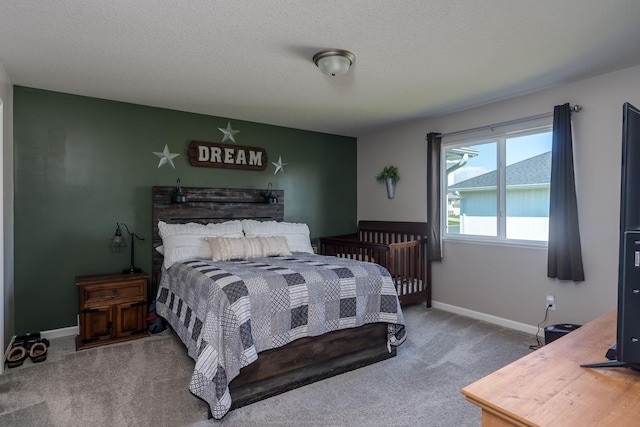 carpeted bedroom featuring baseboards and a textured ceiling