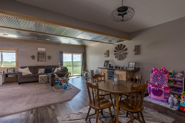 dining area featuring beamed ceiling, beverage cooler, wood finished floors, and a dry bar