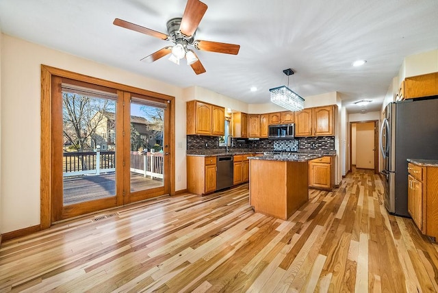 kitchen featuring decorative backsplash, brown cabinets, appliances with stainless steel finishes, and a center island