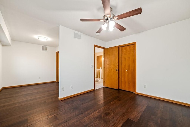 unfurnished bedroom featuring visible vents, baseboards, a closet, and wood finished floors